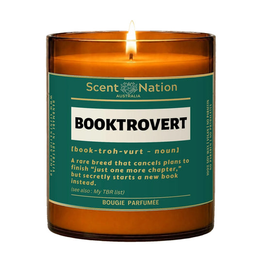 Book gifts for book lovers – Booktrovert candle: lit Large 285 g amber soy candle with a deep teal label and a dictionary-style definition of a booktrovert, Scent Nation Australia