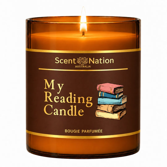 Book lovers gift – My Reading Candle: lit Large 285 g amber soy candle with a brown label, gold lettering and a stack of colourful books, Scent Nation Australia