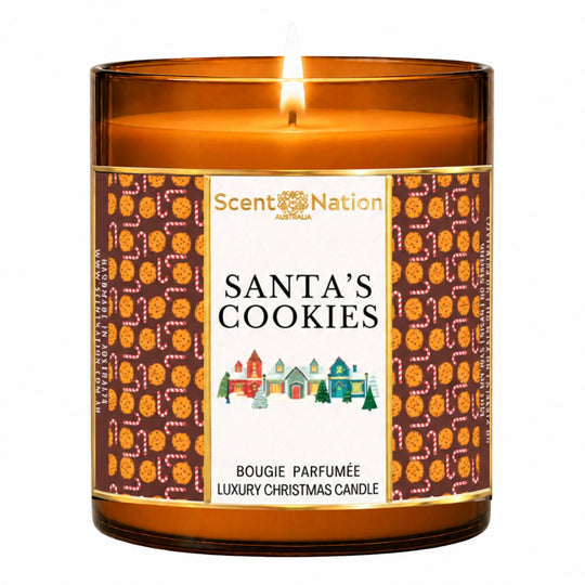 Christmas candle – Santa's Cookies luxury Christmas candle: lit Large 285 g amber soy candle with a cookie-pattern label and Christmas village, Scent Nation Australia